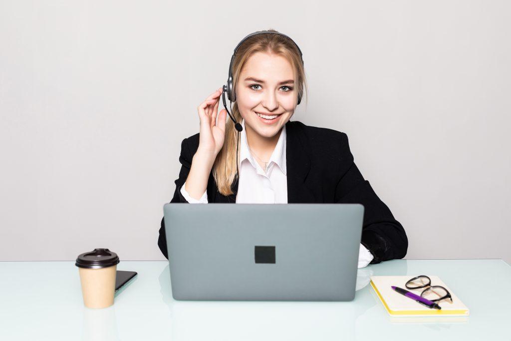 portrait smiling woman with laptop helpline operator with headphones office