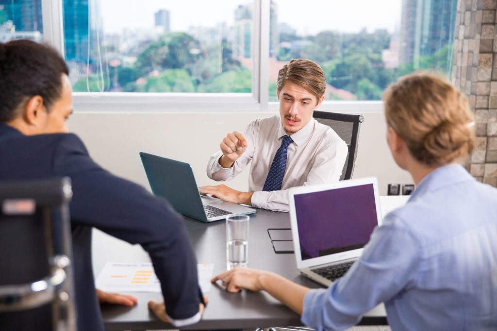 businessman sitting with laptop talking other colleagues 7 Proven ABM Appointment Setting Strategies That Drive Revenue