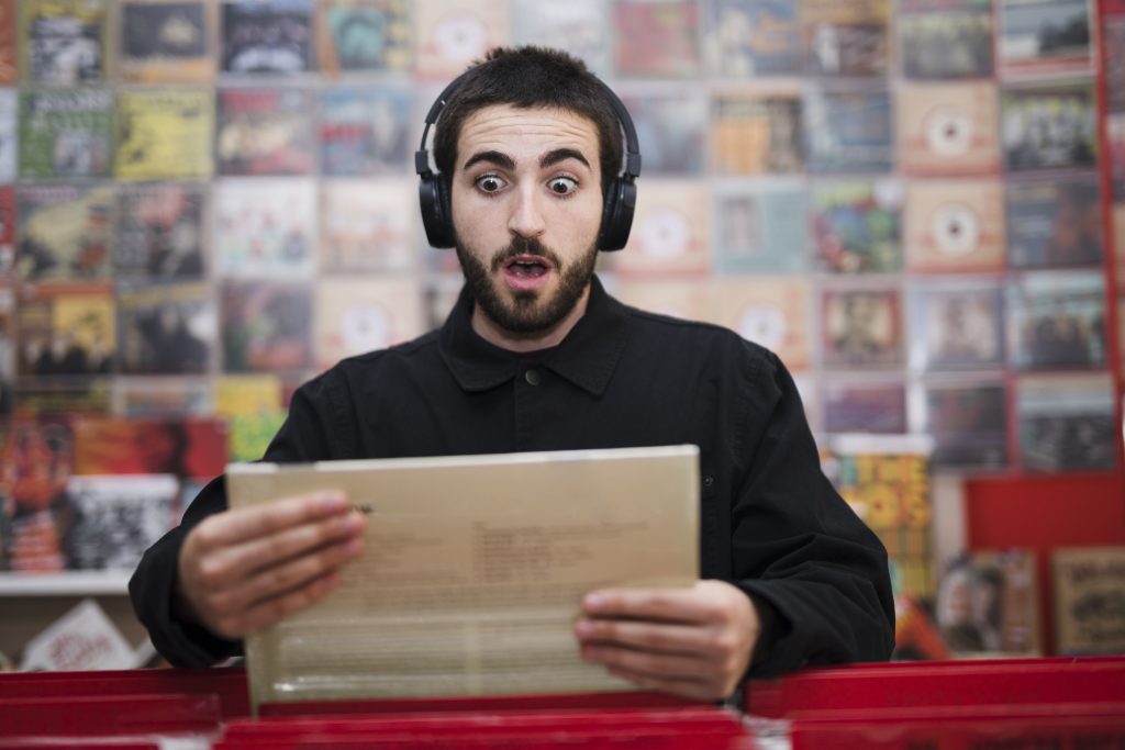 medium shot young man listening music vinyl store Cold Calling vs Email Outreach: 7 Proven Insights for Booking More Meetings