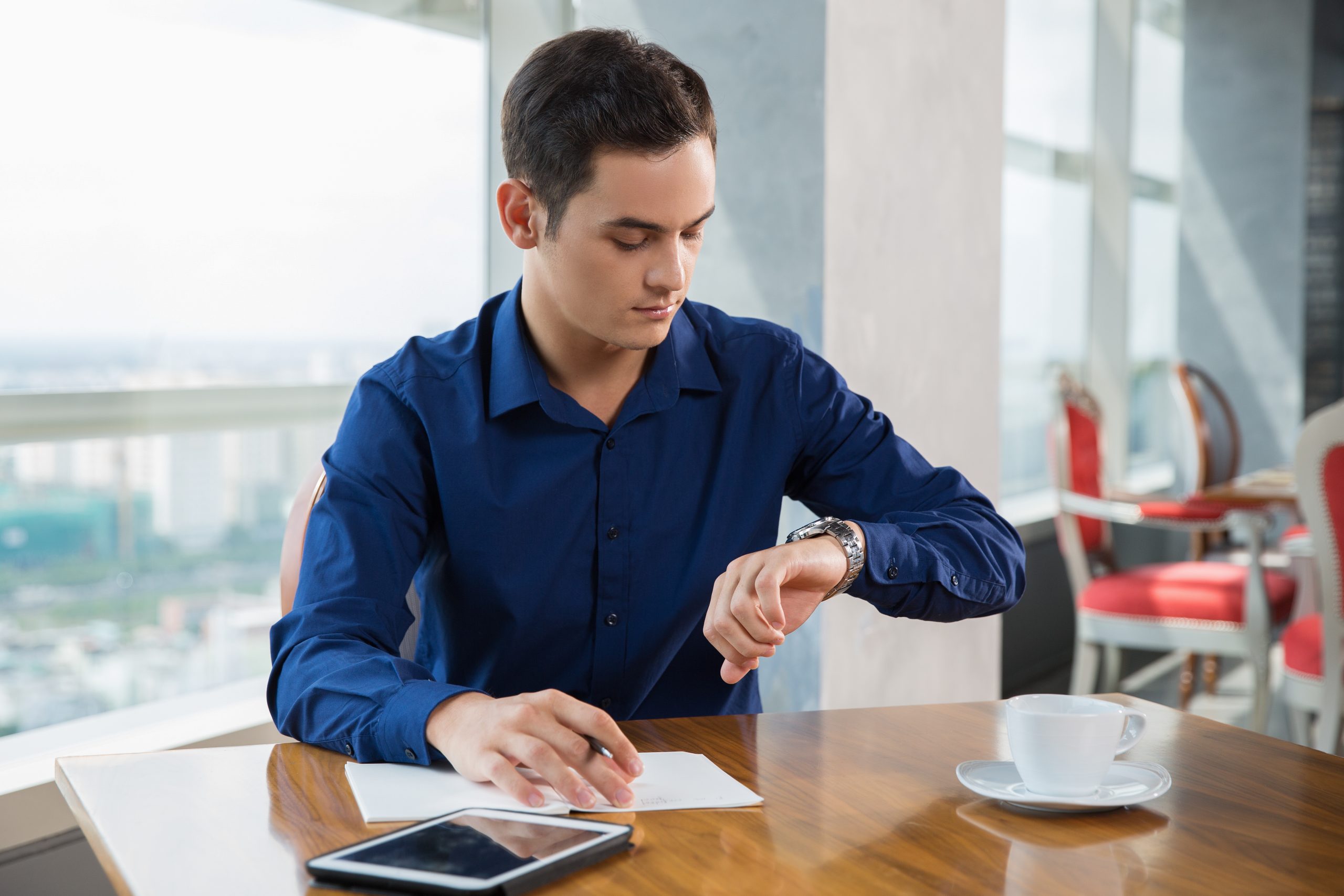 serious young businessman looking wrist watch scaled Basement Remodelling
