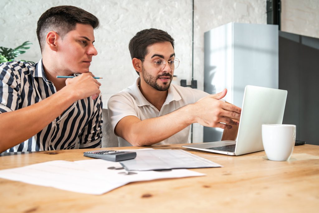young gay couple planning their home budget paying their bills online with laptop while staying home finance concept How ScriptForge Studio Grew Qualified Meetings With Appointment Setter Online
