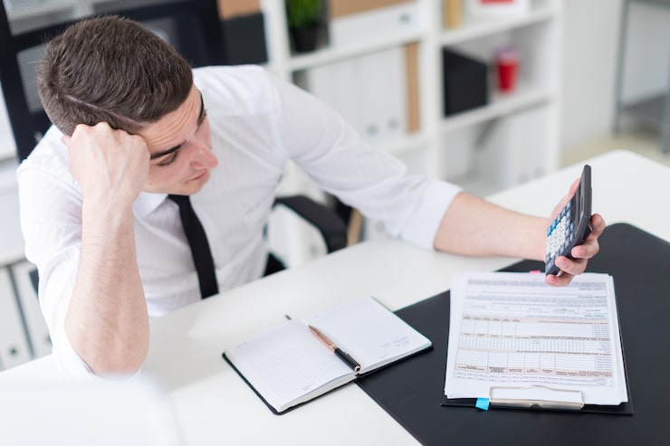 young man sitting computer desk office looking calculator 88135 11229 Common Appointment Setting Mistakes: 11 Costly Errors to Avoid